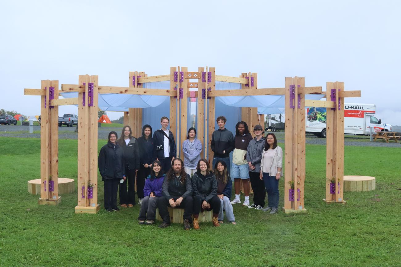 BuildFest participants standing in front of a wood-framed installation.